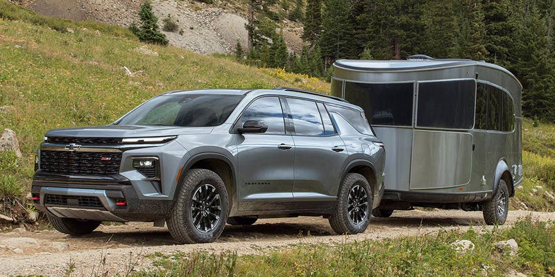 A grey 2026 Chevrolet Traverse towing a trailer. 