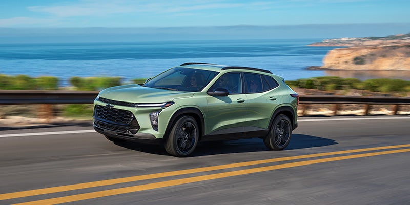 A Cacti green 2026 Chevrolet Trax driving down the road.